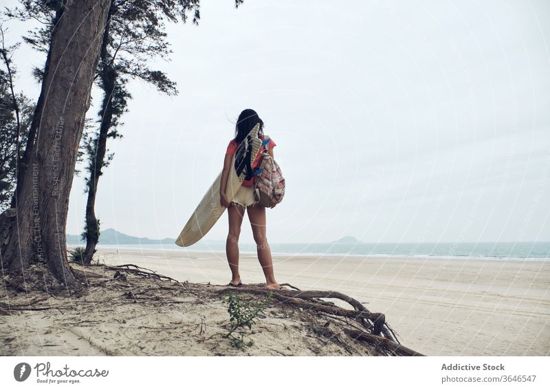 Anonyme Surferin, die mit einem Surfbrett am Strand spazieren geht Frau Spaziergang sandig führen Inhalt MEER lässig Seeküste sorgenfrei Aktivität jung