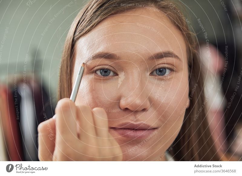 Stylistin beim Auftragen von Eyeliner auf das Modell visagiste Bürste Make-up Atelier Augenbrauen Fokus bewerben Konzentration Klient jung Beruf Kosmetik Pflege
