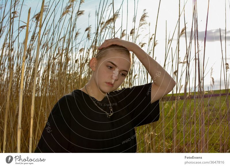 Mädchen mit sehr kurzem Haar in der Natur, Hand oben auf dem Kopf Gras Porträt krank Mode jung Krebs Schmuck Frau attraktiv Haarausfall Chemotherapie im Freien