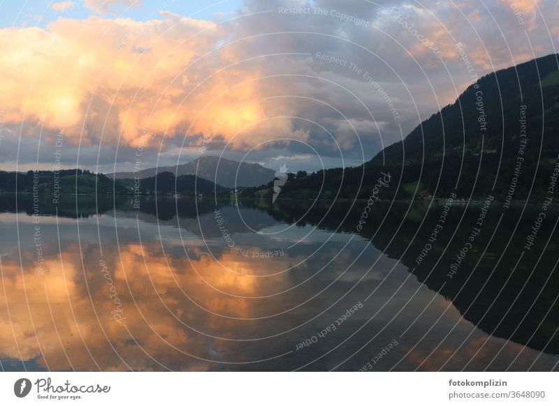 Wolkiger Abendhimmel und Hügelkette spiegeln sich in einem See Spiegelung Landschaft Wolken Himmel Berge u. Gebirge Wasserspiegelung Allgäu Alpsee