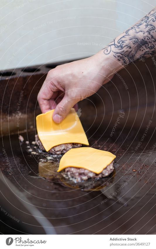 Männlicher Koch bereitet Burger im Café zu vorbereiten Kotelett Käse Mann hinzufügen Prozess geschmackvoll Fleisch männlich Küchenchef lecker frisch