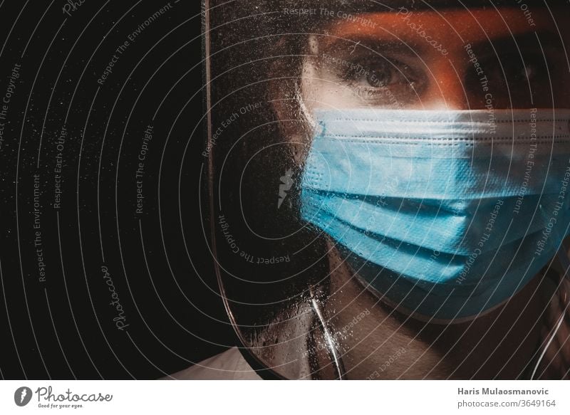 Weibliche Heldenärztin mit Maske und Schild auf schwarzem Hintergrund 2020 Atemschutzmaske schwarzer Hintergrund filmisch Klinik Korona-Epidemie Corona-Virus
