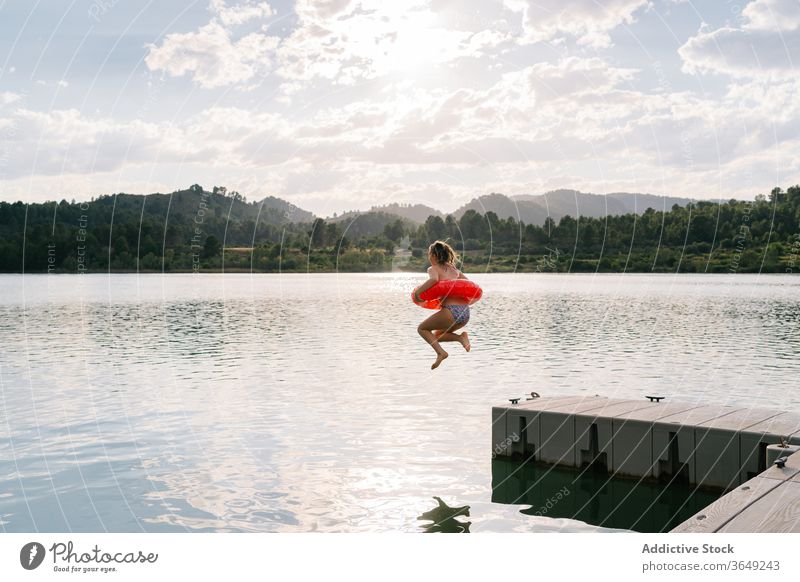 Mädchen springt mit aufblasbarem Ring in den See springen Gummi Teich Bikini Sommer Urlaub Spaß haben Teenager Moment Wasser Glück Erholung sich[Akk] entspannen