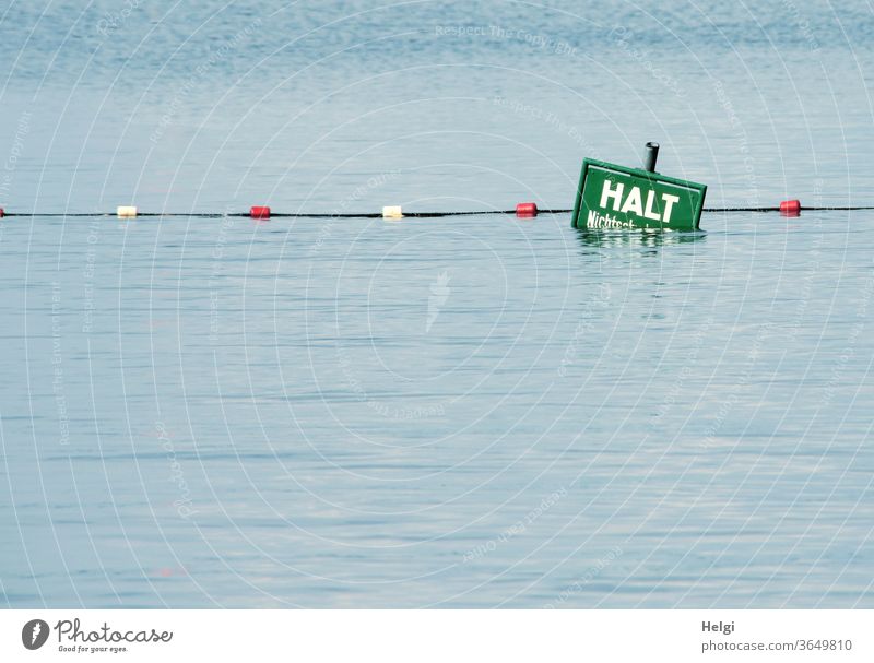 HALT - halb im Wasser versunkenes Warnschild mit Absperrseil am Ende eines Nichtschwimmerbereiches im See Absperrung Halt Warnung Vorsicht Gefahr Sicherheit