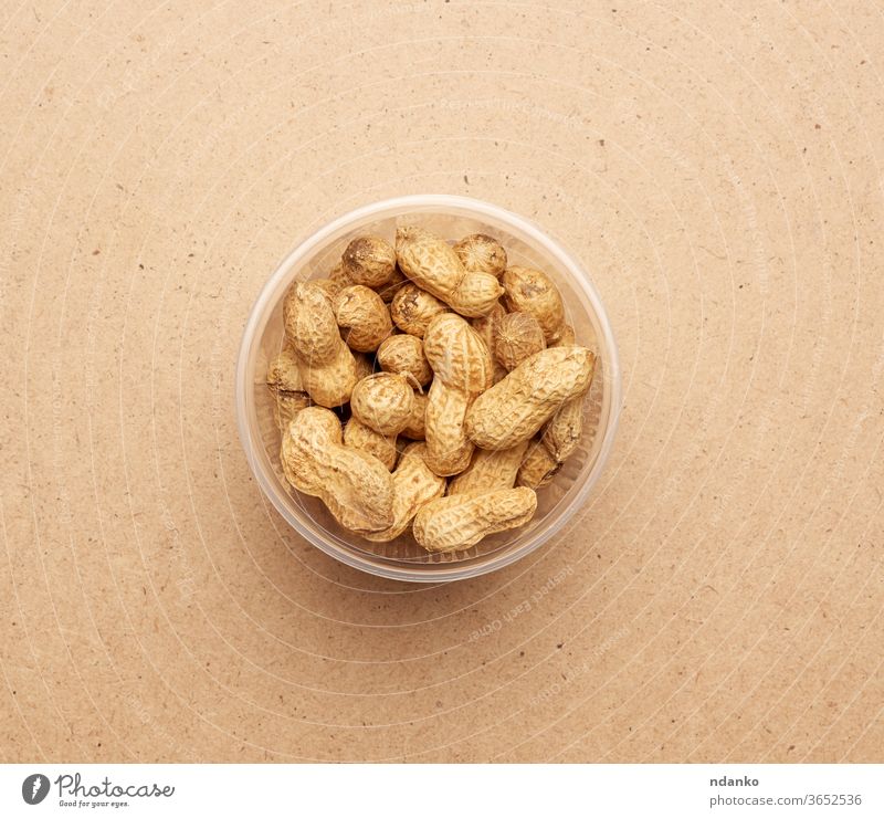 Inshell-Erdnüsse in einer durchsichtigen Plastikschale Nut Nährstoff Ernährung Nussschale offen organisch Erdnuss sich[Akk] schälen Haufen Hülse roh Samen