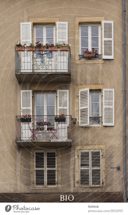 Fassade eines Wohnhauses über einem Bioladen in Metz Lothringen alt Balkone Klappläden Holz Regenfallrohr Fenster Text Haus außen Wohnungen Altbau