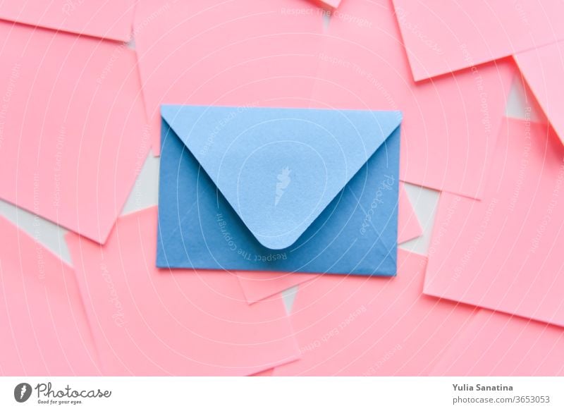 selektiver Fokus, blauer Umschlag auf dem Hintergrund von Korallenaufklebern rosa Kuvert Design Postkarte Liebe Brief vereinzelt Kulisse Hochzeit Papier Kunst