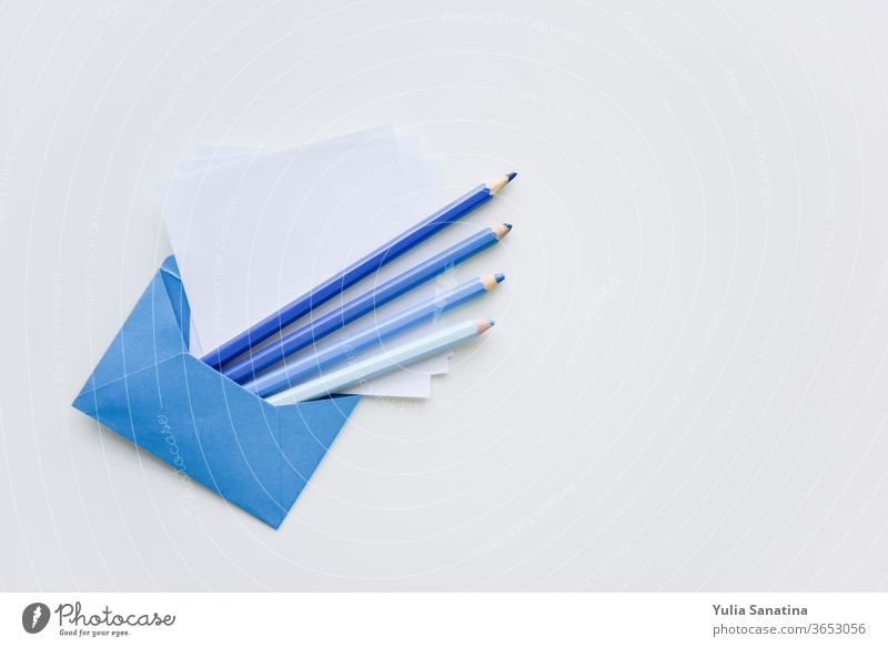 selektiver Fokus, blaue Stifte und weißes Papier aus dem blauen Umschlag mit Kopierraum oben Kuvert Bleistift Schot Hintergrund Nachricht blanko Brief Büro leer