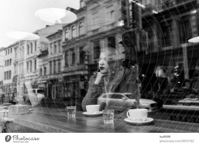 die junge Frau wartet im Kaffee und blickt verträumt nachdenklich aus dem Fenster Frauengesicht Junge Frau 1 Porträt Jugendliche Frauenaugen straßenkaffee