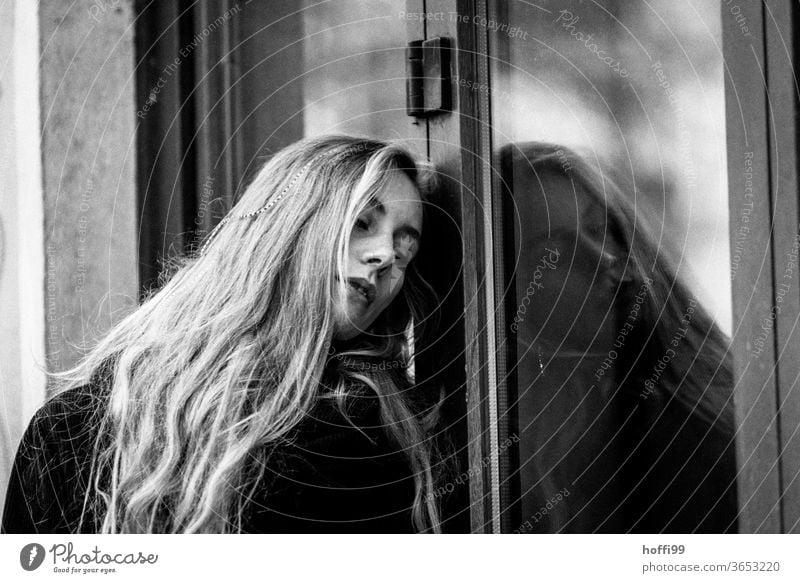 die junge Frau lehnt sich verträumt melancholisch an eine Fensterscheibe Junge Frau Porträt Frauenaugen Frauengesicht Jugendliche Mensch Erwachsene 18-30 Jahre