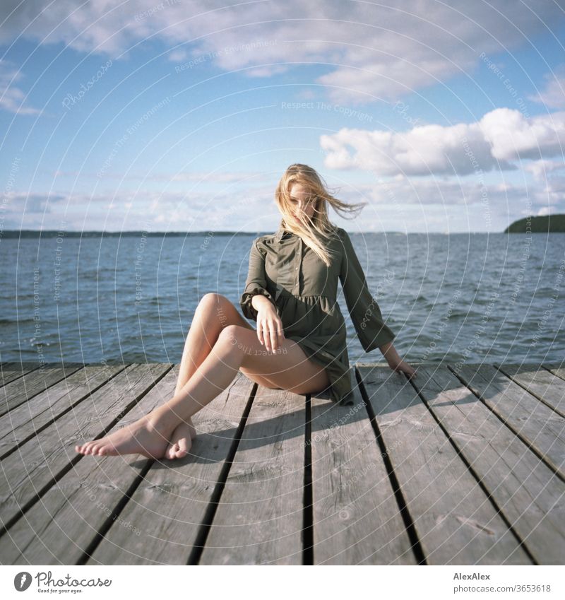 analoges Ganzkörper- Portrait einer jungen, blonden, barfüßigen Frau auf Holzsteg im Meer junge Frau schön schlank langhaarig windig ästhetisch Sommer Ausflug