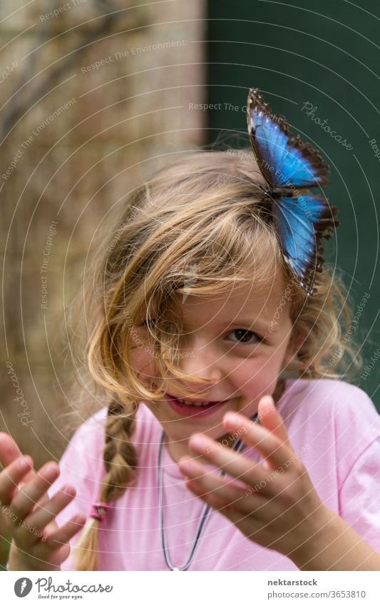 Porträt eines glücklichen blonden Mädchens mit blauem Schmetterling im Haar Kind Glück Lächeln im Freien Natur Schönheit in der Natur Tag Sommer