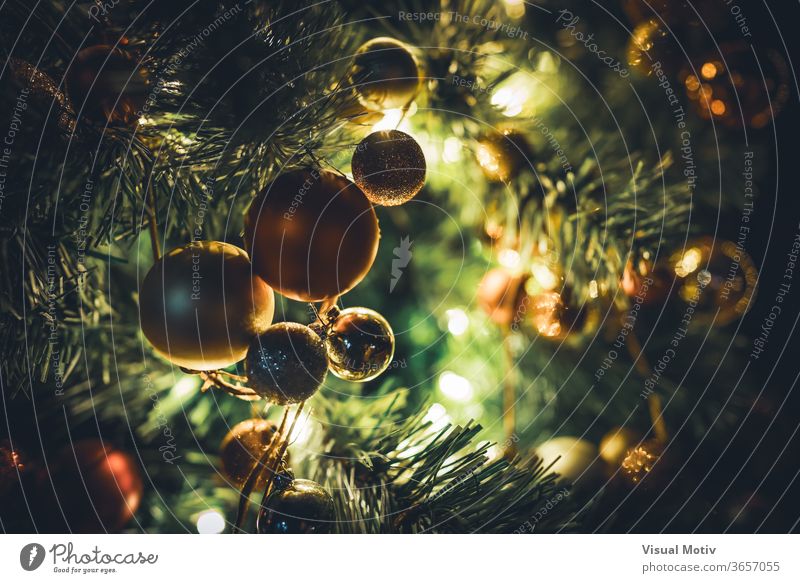 Traditionelle Weihnachtsbaumgirlande mit Kugeln, die nachts an beleuchteten Zweigen hängen traditionell Weihnachten Baum Girlande Ast Licht Feiertag feiern