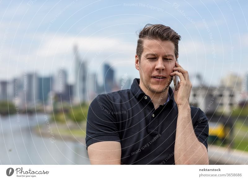 Mann im Gespräch über Mobiltelefon und Stadtsilhouette Erwachsener Skyline Handy Wolkenkratzer Metropole Mobiltechnologie Telekommunikation Hauptfluss modern