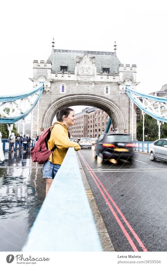 Mädchen in der Londoner Brücke in einem regnerischen Tag Junge Frau junges Mädchen Teenager Smiley Lächelndes Gesicht glückliches Mädchen gelb
