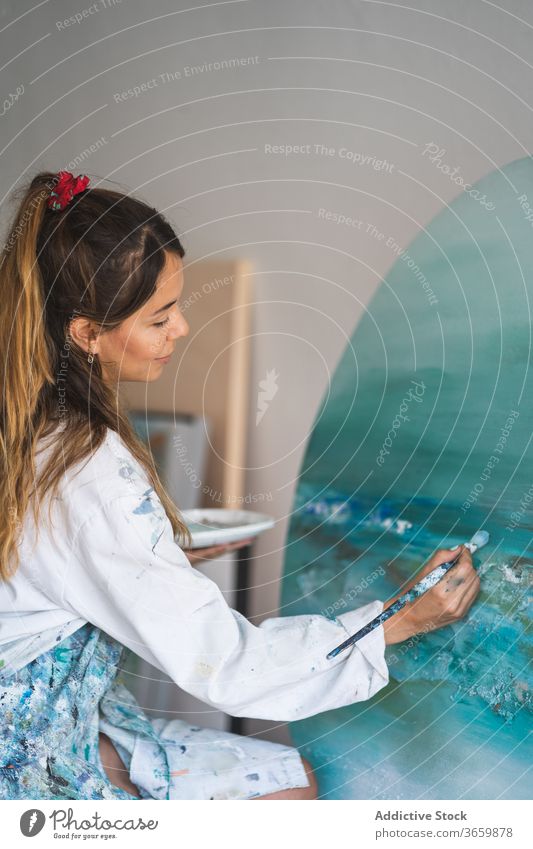 Weibliche Künstlerin malt Bild auf Staffelei Farbe Leinwand Meereslandschaft Frau kreativ Kunst Talent jung Pinselblume zeichnen Lifestyle Hobby Inspiration
