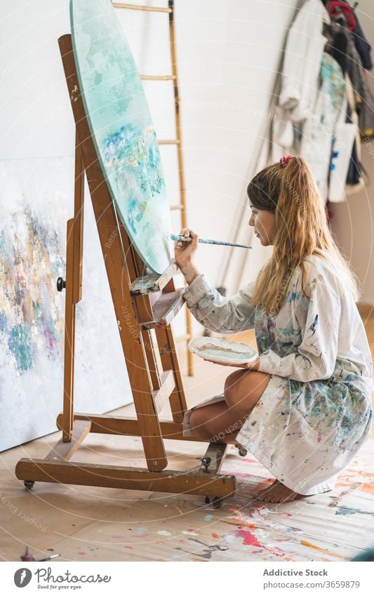 Weibliche Künstlerin malt Bild auf Staffelei Farbe Leinwand Meereslandschaft Frau kreativ Kunst Talent jung Pinselblume zeichnen Lifestyle Hobby Inspiration
