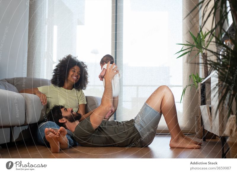 Glückliche multiethnische Familie entspannt zu Hause Einheit sich[Akk] entspannen heimwärts Zusammensein spielen Baby neugeboren bezaubernd Inhalt Spaß haben