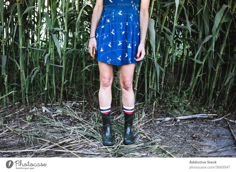 Erntehelferin in Gummistiefeln auf dem Feld Landschaft Frau Stiefel genießen Sonne Sommer Natur Kleid Freiheit blau Gelassenheit stehen sorgenfrei Gras ländlich