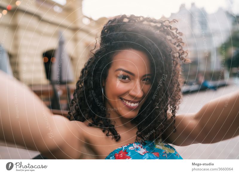 Afroamerikanische Frau, die sich in der Stadt ein Selfie gönnt. Großstadt Menschen Amerikaner Afro-Look Porträt Spaß cool Selbst Lächeln lockig Behaarung unter