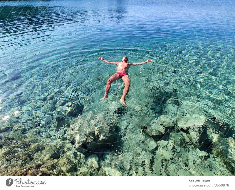 Der Mensch entspannt sich im Urlaub, schwebt im ruhigen, türkisfarbenen Meer. Im Wasser treiben Sommer Schwimmen & Baden Ferien & Urlaub & Reisen Strand