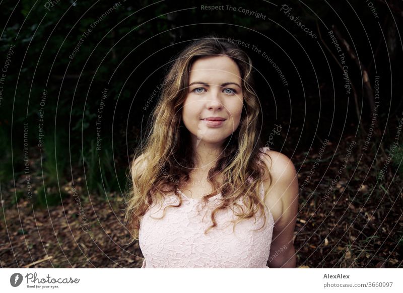 Nahes Portrait einer jungen Frau vor einem Wald lockig Reinheit Glück Schönes Wetter Ausflug Erwartung Sonnenlicht Freude Nahaufnahme feminin Tag