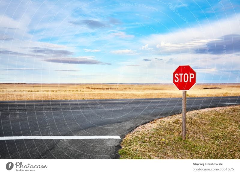 Stoppschild an einer Kreuzung im Badlands-Nationalpark, USA. stoppen Straße Zeichen reisen Ausflug Autobahn Natur Landschaft ländlich Ödland Nationalpark