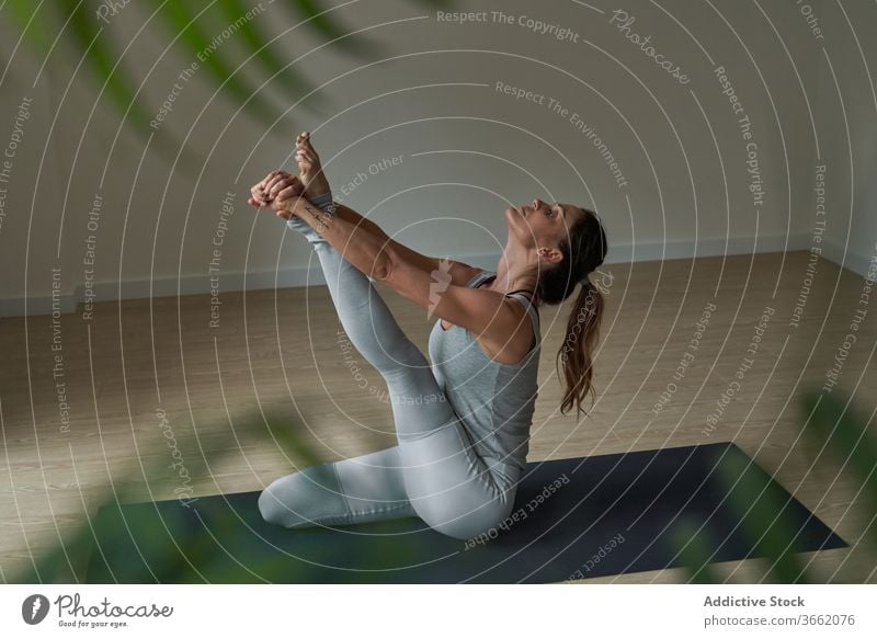 Fokussierte Frau, die Krauncasana Dehnungsyoga-Pose ausführt üben Yoga Atelier Reiher beweglich Windstille Wohlbefinden Gleichgewicht Harmonie Wellness passen