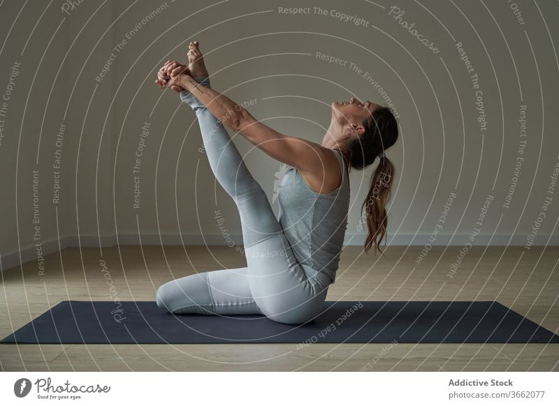 Fokussierte Frau, die Krauncasana Dehnungsyoga-Pose ausführt üben Yoga Atelier Reiher beweglich Windstille Wohlbefinden Gleichgewicht Harmonie Wellness passen