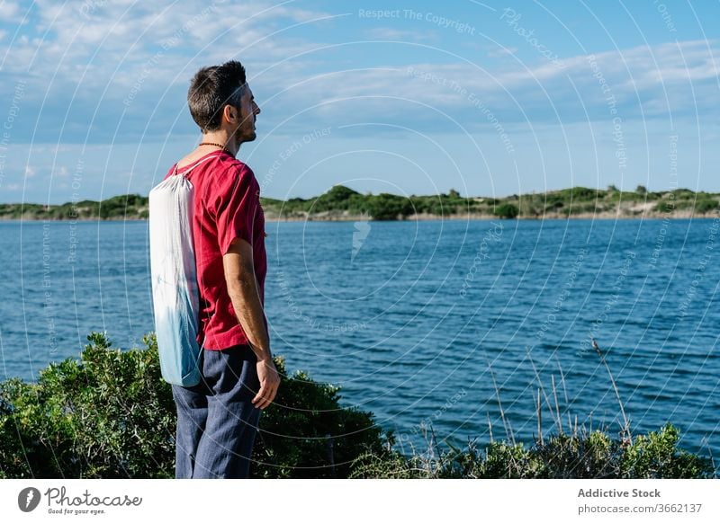 Nachdenklicher junger Mann genießt Meereslandschaft vor blauem Himmel sich[Akk] entspannen Hügel MEER bewundern Windstille friedlich Erholung Natur Harmonie