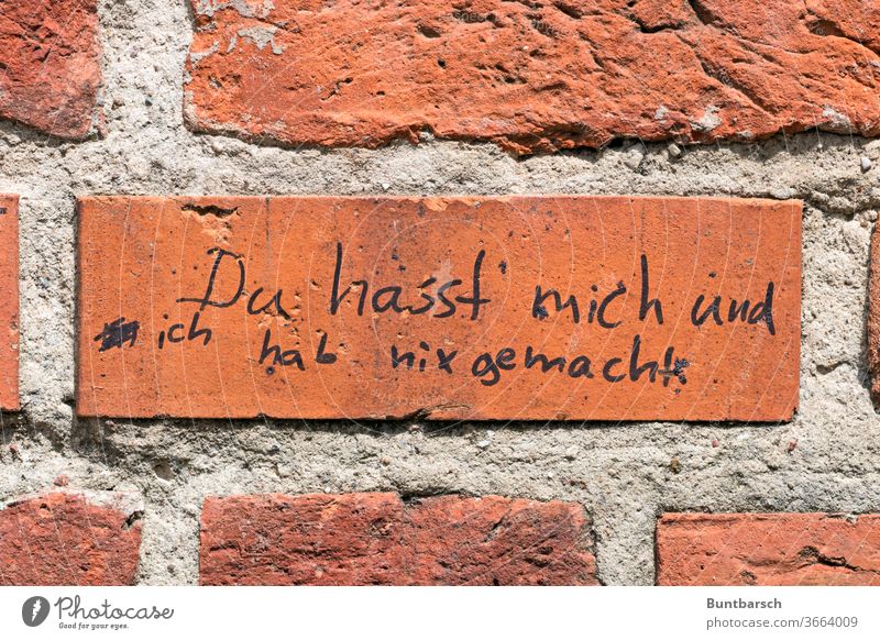 Schriftzug auf Ziegelwand: „Du hasst mich und ich hab nix gemacht“ Hass Text Wand Außenaufnahme Buchstaben Schriftzeichen Wort Menschenleer Mauer Kommunikation