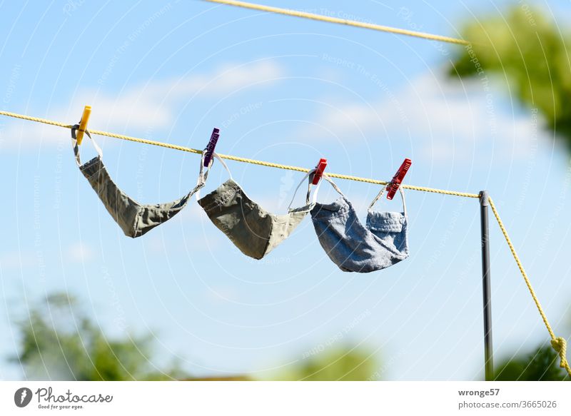 Frisch gewaschen hängen 3 selbstgenähte Mundschutzmasken zum Trocknen auf der Wäscheleine 3 Stück frisch gewaschen selbstgemacht trocknen Sauberkeit Waschtag