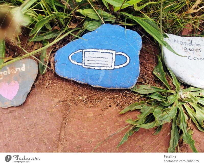 Kleine Botschaften - oder ein Mund-Nasen-Schutz auf Stein gemalt Helgoland Steine Farbe bemalt Kunstwerk Schrift Buchstaben Corona Mund-Nasen-Maske weiß blau