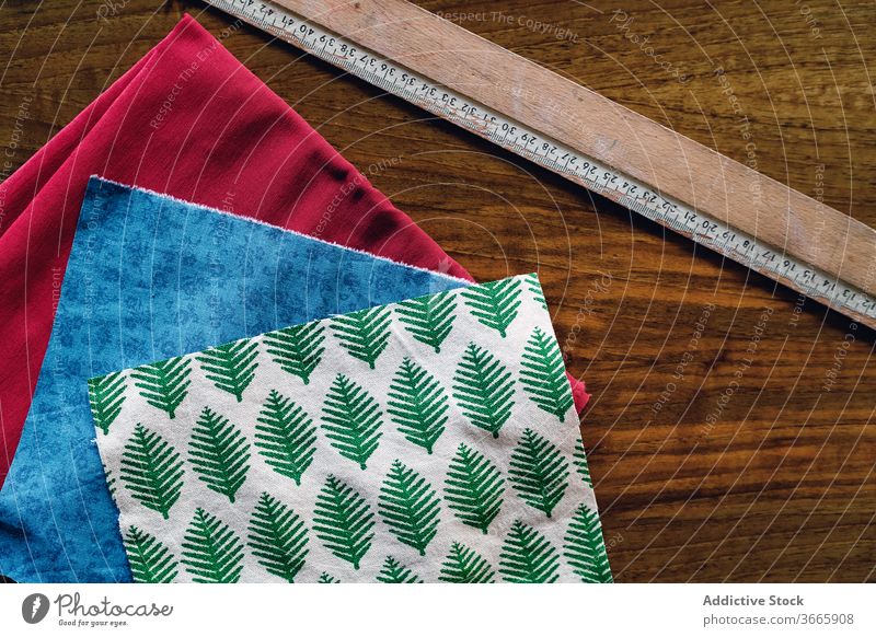 Satz sortierter Stoffmuster mit bunten Mustern im Atelier Textil Probe Lineal Basteln Ornament Baumwolle Kleinunternehmen hölzern Tisch farbenfroh Gewebe