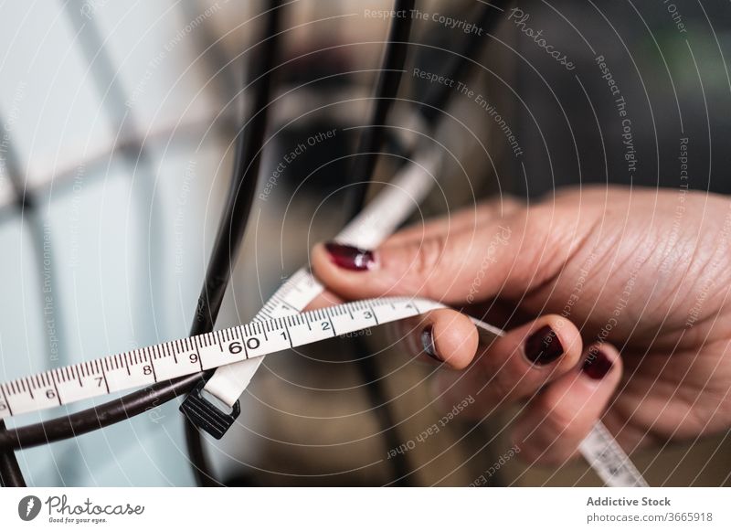 Anonyme Frau, die Messungen an einem verkabelten Dummy vornimmt Mode Bekleidung Meter messen Draht Metall Figur Nähen Schaufensterpuppe Formular Designer