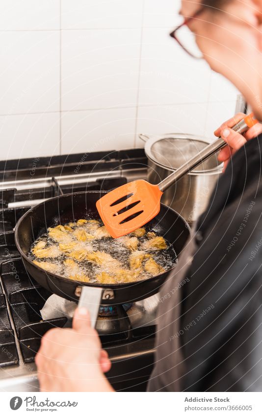 Anonymer Chefkoch brät Artischocken in der Küche. Lebensmittel Feinschmecker Küchenchef Speise Essen zubereiten Mahlzeit frisch Restaurant geschmackvoll