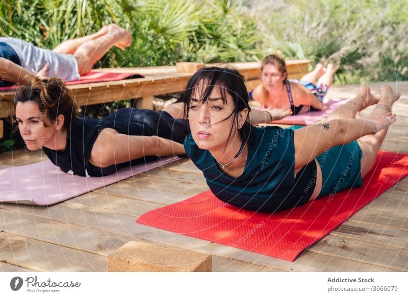 Personen, die während des Yoga-Trainings Körperhaltung einnehmen Frauen Menschen salabhasana Heuschrecke Lager Lektion Wellness Dehnung Ausbilderin Asana