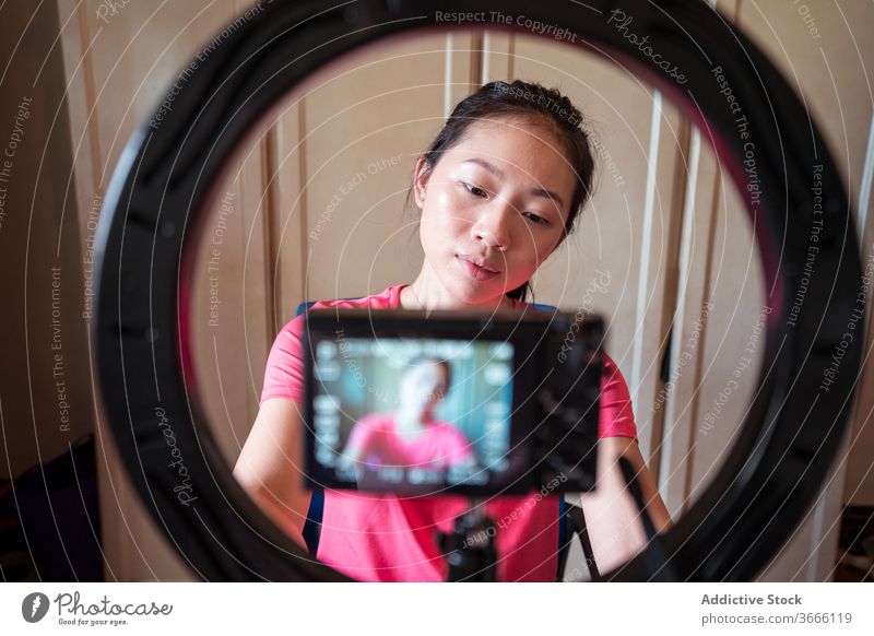 Schönheitsbloggerin stellt die Kamera vor der Videoaufnahme ein Blogger vlog Frau Fotokamera vorbereiten Einstellung Aufzeichnen Ring Lampe Licht Stativ jung