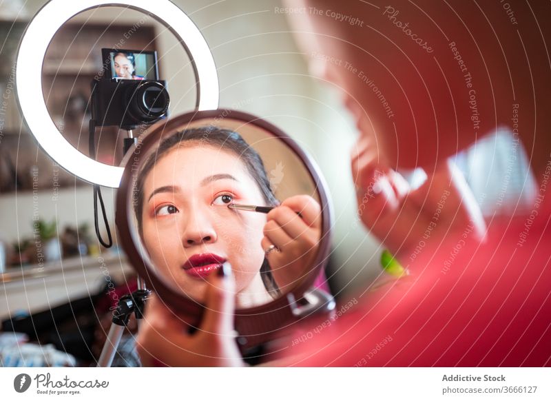 Asiatische Schönheitsbloggerin beim Schminken vlog Blogger Frau bewerben Make-up Lidschatten Kosmetik Video schießen Influencer Bürste Auge Spiegel Aufzeichnen
