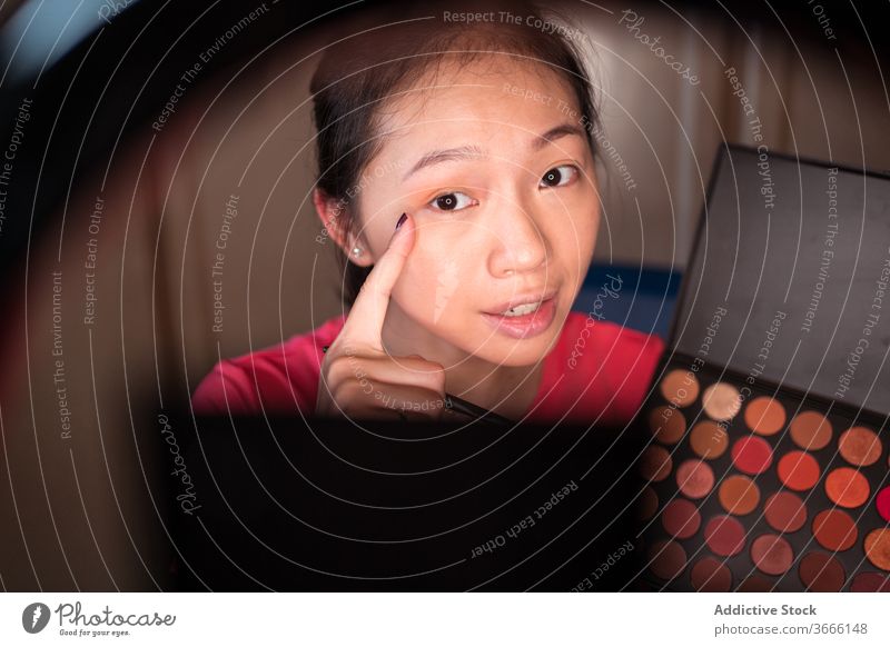 Schönheitsbloggerin mit Make-up-Palette nimmt Video auf vlog Blogger Frau Kosmetik Aufzeichnen manifestieren positiv jung asiatisch ethnisch zeigen Lächeln