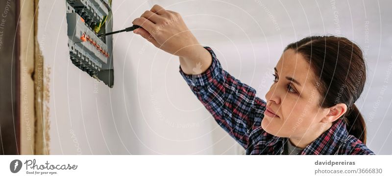 Elektriker, der an der Verteilertafel eines Hauses arbeitet Frau Elektrotechniker Schraubendreher Elektromonteur Elektroinstallation Besichtigung Prüfung