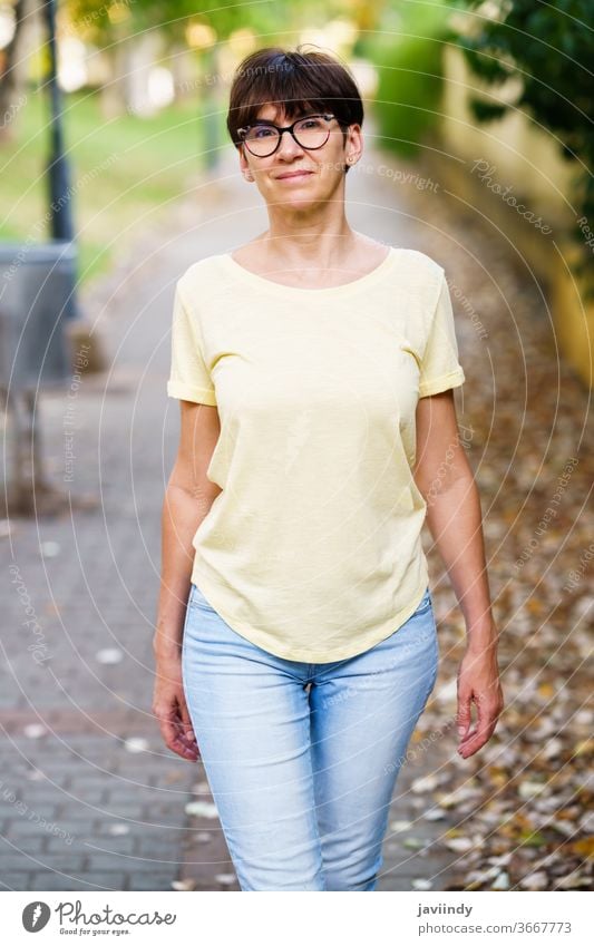 Schöne Frau mittleren Alters geht die Straße entlang 50s im Freien Attrappe niedlich Lifestyle lässig Kaukasier Single Sitzen schön Freizeit Person Brille