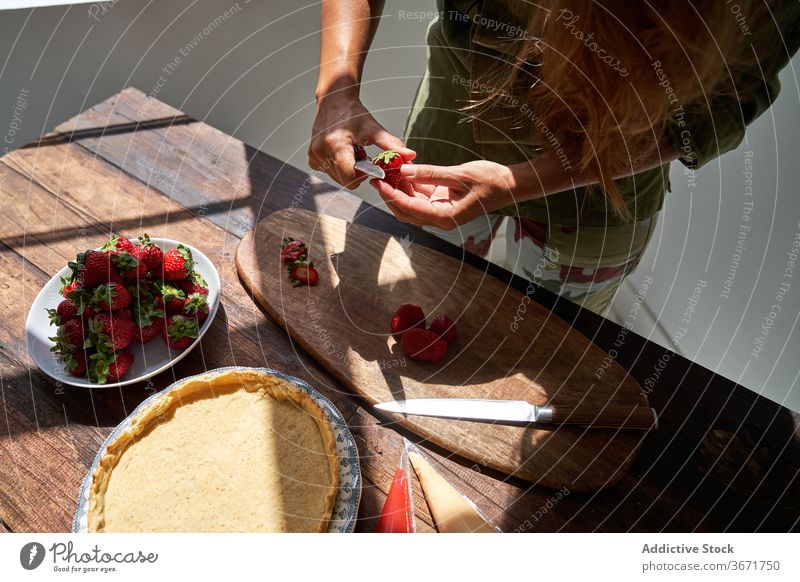 Crop Hausfrau bereitet leckeren Kuchen zu Hause Koch selbstgemacht Pasteten Frau Küche Dessert sich[Akk] schälen Erdbeeren vorbereiten Produkt Prozess frisch