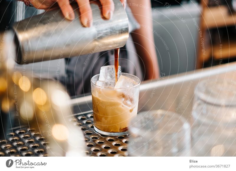 Zubereitung eines kalt gemixten Kaffees auf Eis Eiskaffee geshaked Caffé Freddo bar café gastronomie Getränk Sommer Koffein Shakerato gießen shaker Glas