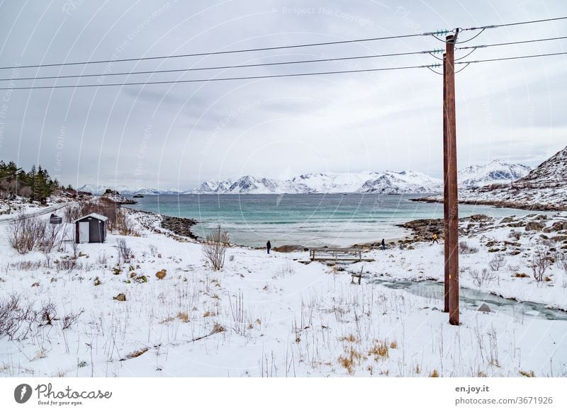 Schneelandschaft an einer Bucht auf den Lofoten Lofoten Inseln Norwegen Skandinavien Winter Kalt Meer Fluss Eis Strand Felsen Urlaub Reise