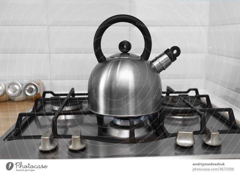 Metallkessel auf einem Gasherd. Kessel kocht auf einem Gasherd. Fokus auf einen Ausguss. Teekessel mit kochendem Wasser auf einem Gasherd Wasserkessel Herd