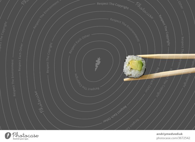 frische vegetarische Maki-Sushi-Rolle mit isolierten Holzstäbchen auf grauem Hintergrund. rollen Lebensmittel Granele maki Sea Bass Sashimi Wasabi vereinzelt