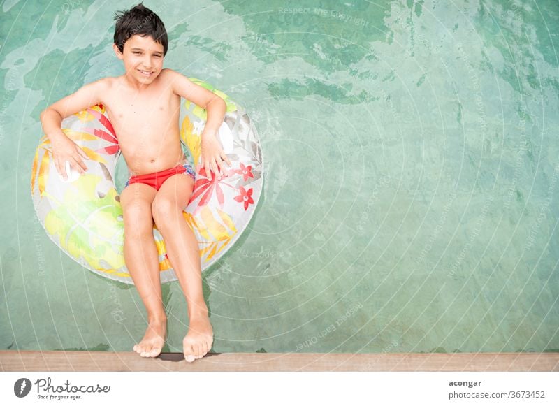 Junge, der auf einem aufblasbaren Kreis im Schwimmbecken schwimmt. Kind blau sorgenfrei Kaukasier Kindheit bequem cool niedlich Genuss Schwimmer Schwimmerrohr