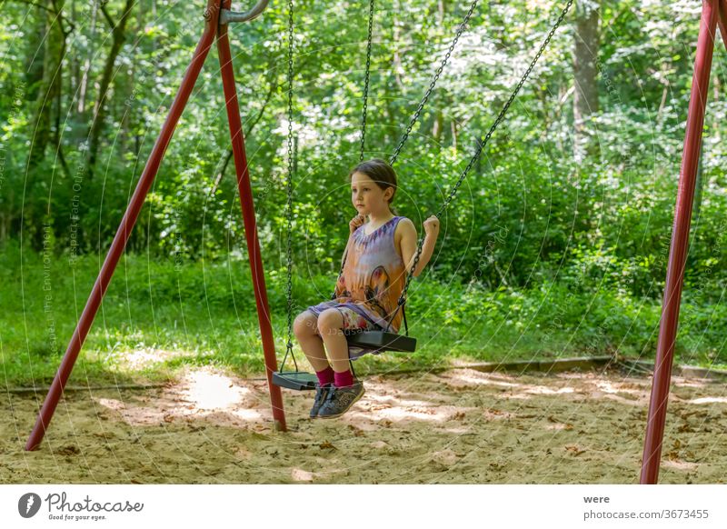 Kleines Mädchen auf einer Schaukel im Wald Kind Spielen Freude Sommer Bewegung Spielplatz Kleinkind Fuß Motorik Schulhof Wiese Spieltrieb Kindheit Turnen Pause