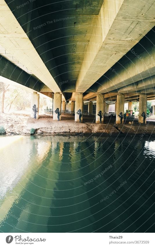 Grünes Flusswasser unter der Brücke Zementkonstruktion, Reflexion über Wasser Linien Maschinenbau Struktur Industrie Perspektive Brückenkonstruktion